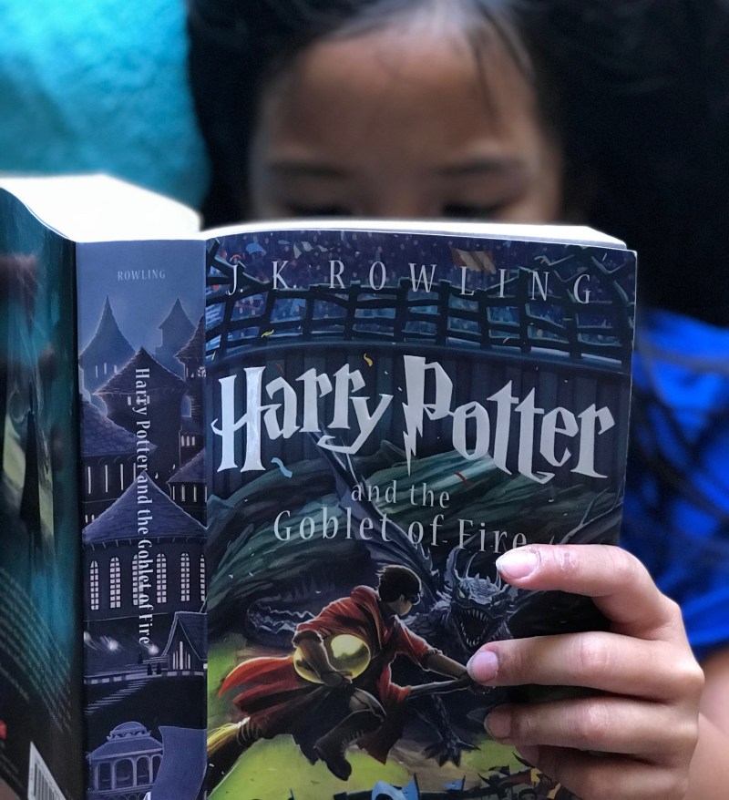 My little sister reading Harry Potter and the Goblet of Fire. She's at the point where she can read the books now, and she was influenced by me.