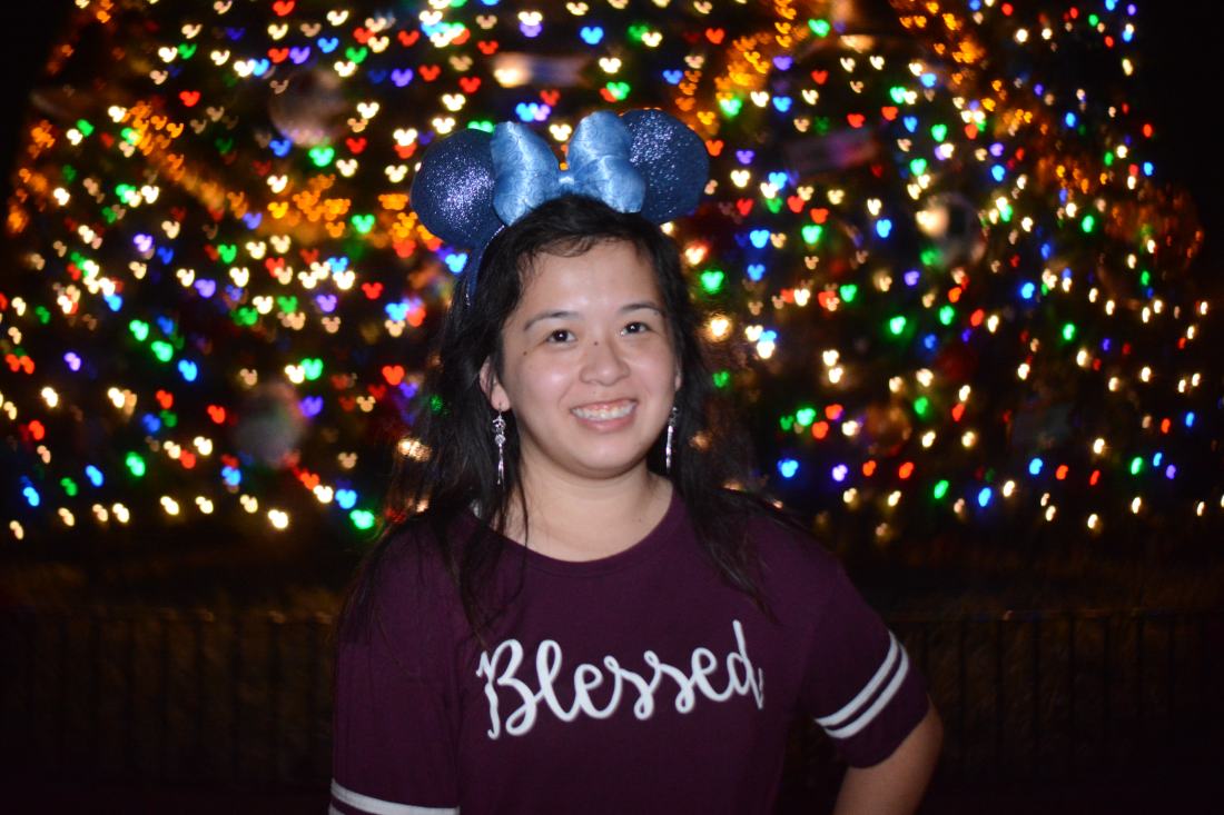A photo of me with the Christmas Tree at Epcot during the Festival of Holidays.