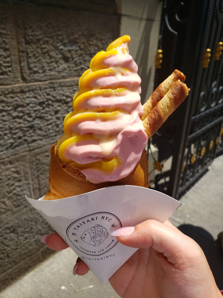 A taiyaki is a fish-shaped waffle. This is a fish-shaped waffle filled with strawberry and mango ice cream.