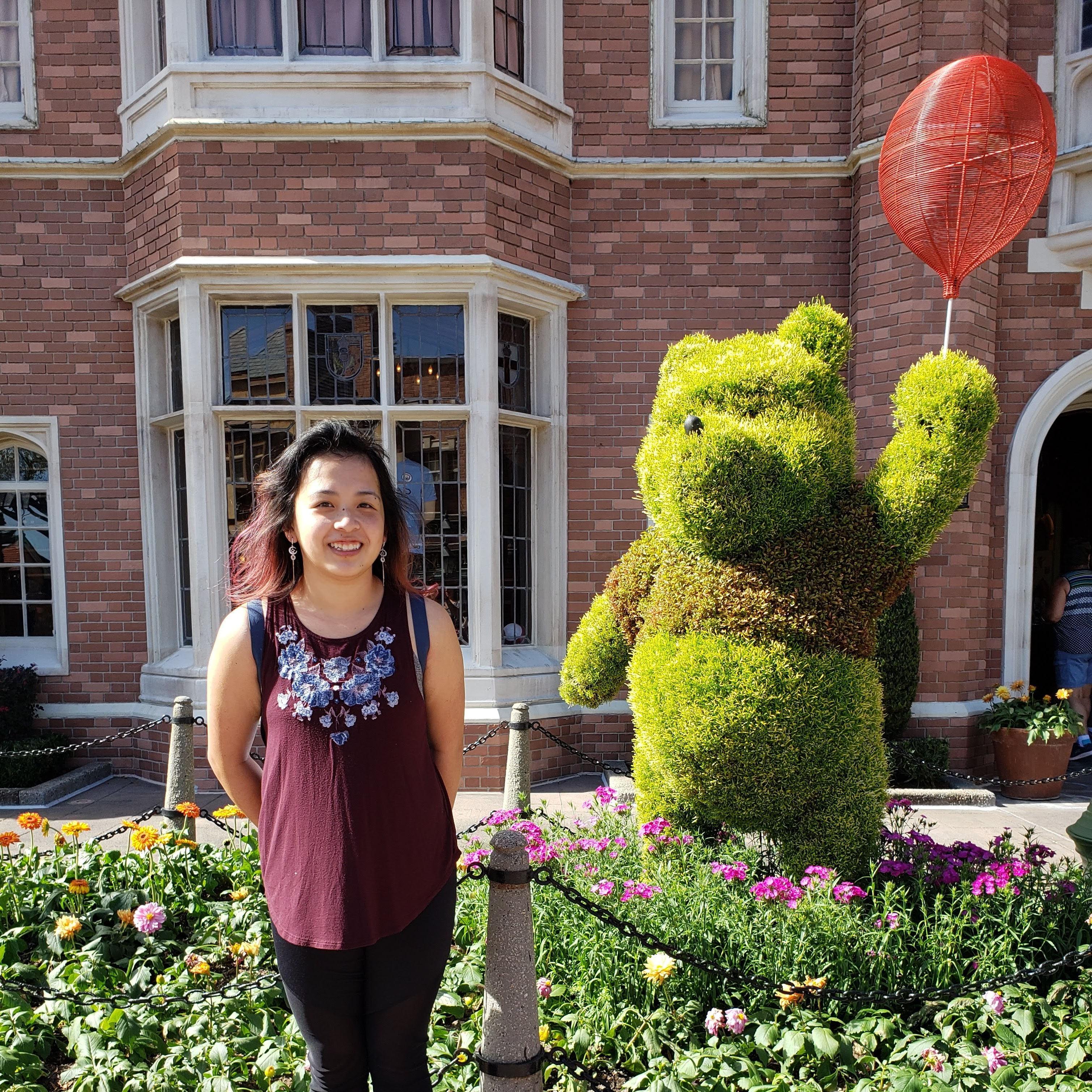 A photo of me and a Pooh Bear topiary in the London area of Epcot.