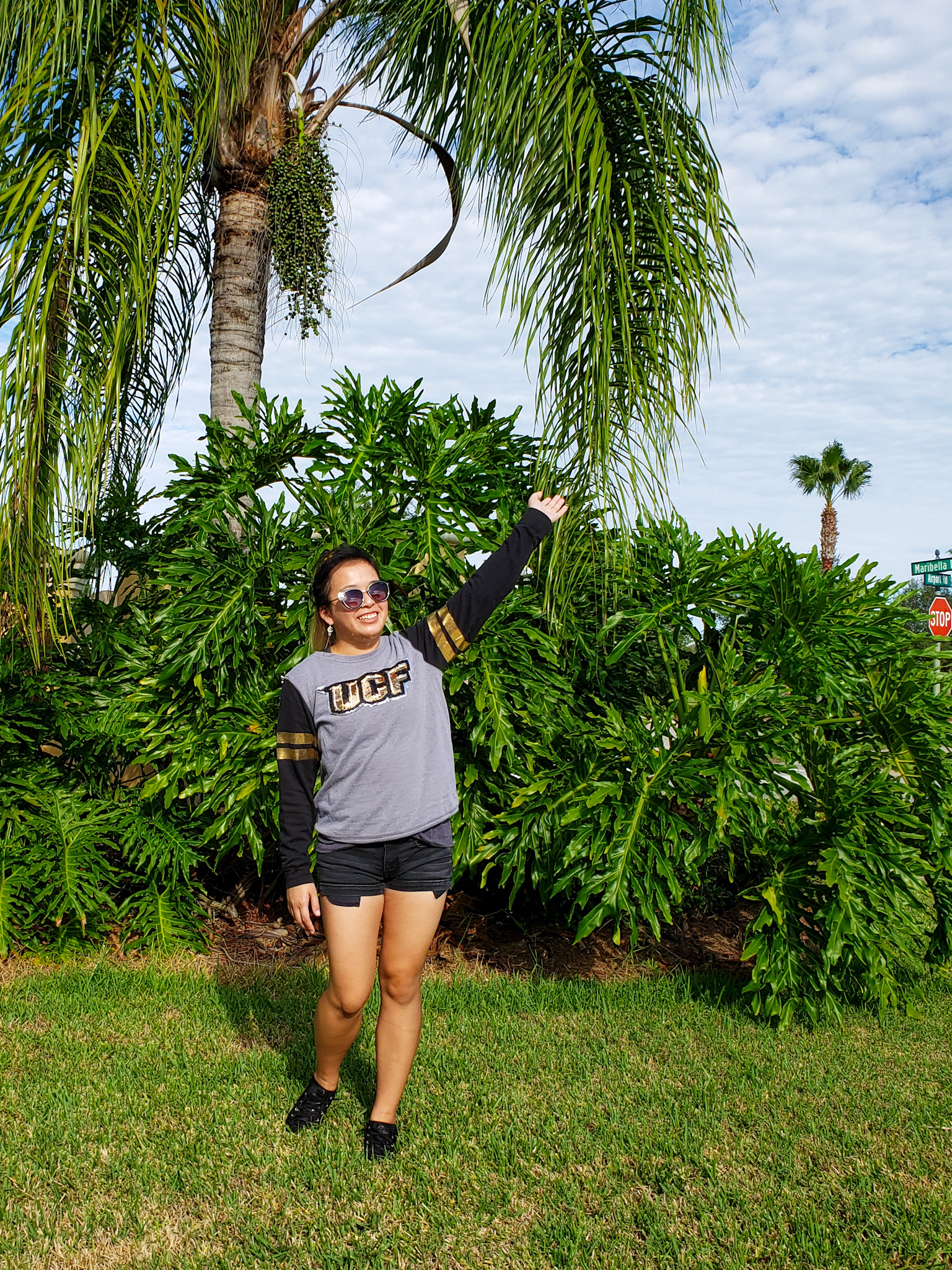 Me in shorts and a school spirit sweatshirt outdoors.