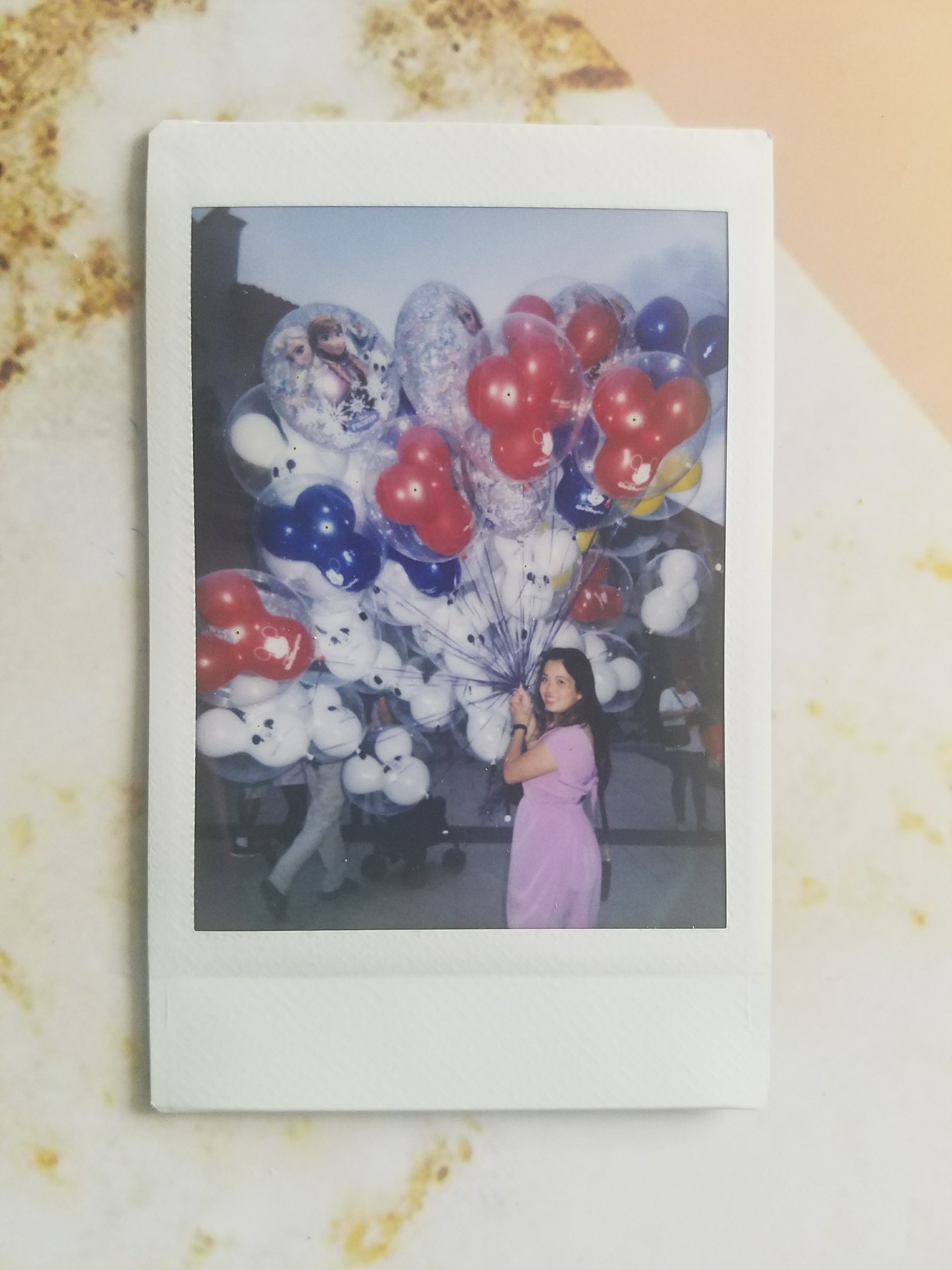 A photo of me with balloons at Disney Springs. It reminds me of the movie Up, which I watched for the first time on my 22nd birthday, 10 years after it was released.