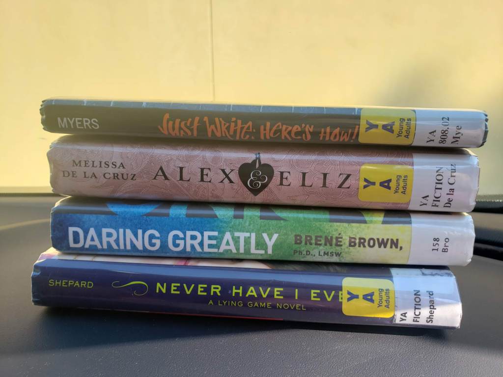 I recorded a video of me going to the library in my car, so I thought it would be fitting of me to take a photo of my library stack in the car as well. Pictured is Daring Greatly by Brene Brown, Never Have I Ever by Sara Shepard, Alex & Eliza by Melissa de la Cruz, and Just Write by Walter Dean Myers.