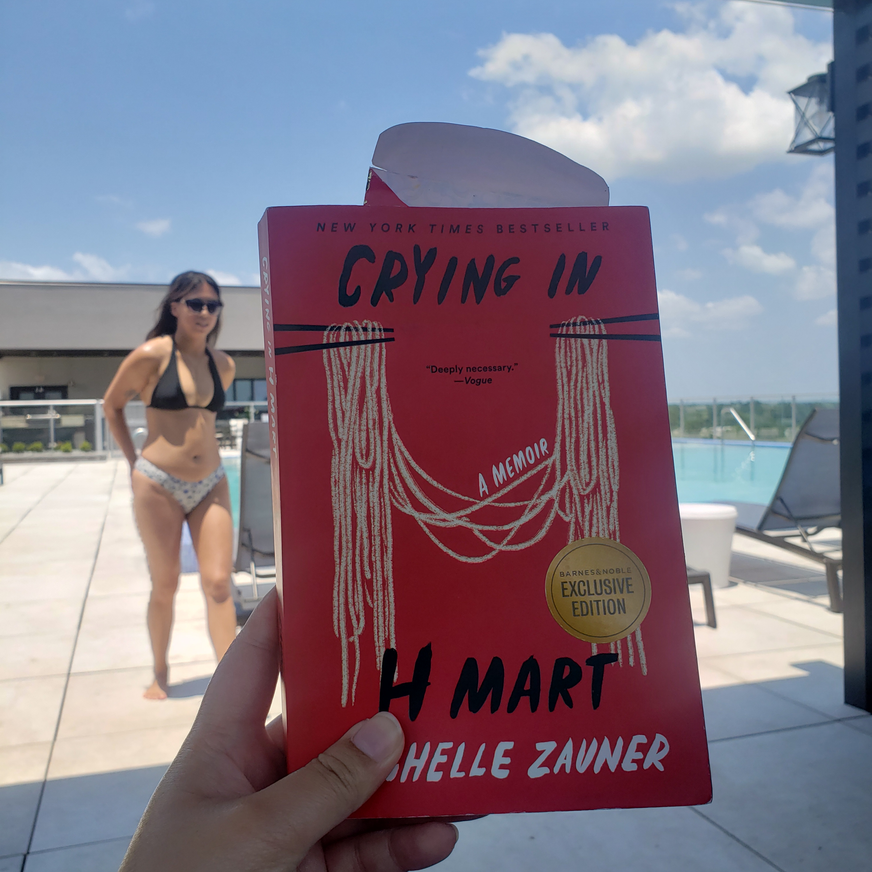 I didn't take a photo of Crying in H Mart by Michelle Zauner while I was at work, but I did take one when I was reading it at the pool. My sister Kristina is in the background walking towards me.