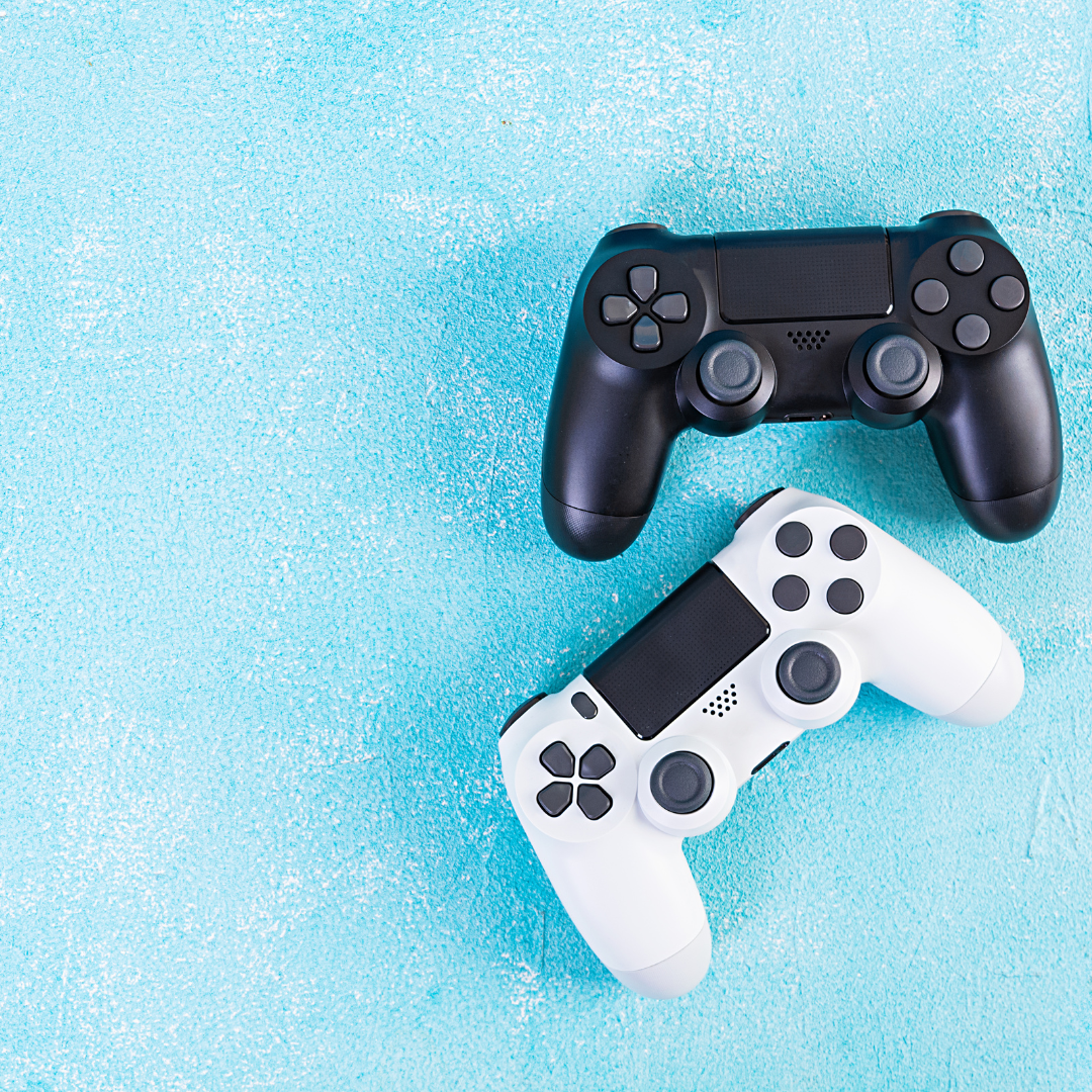 One black game control and one white game control sitting on a blue background.