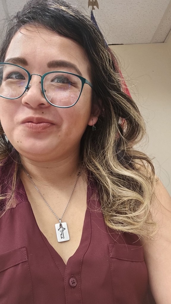 This is a selfie I took in the classroom, probably before my students came in that day. I'm wearing a maroon button up and my emerald green glasses. My hair is curled.